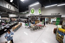 Customers shopping in front end near deli and pickup areas 