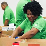 Publix associate packing a box of food to donate 