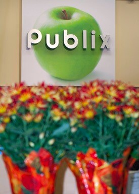 Publix logo on apple photo with fresh flowers underneath