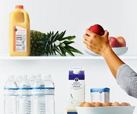 Hang reaching for an apple on a shelf with other Publix products