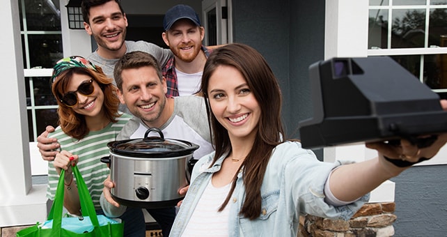 group taking a selfie while holding slow cooker